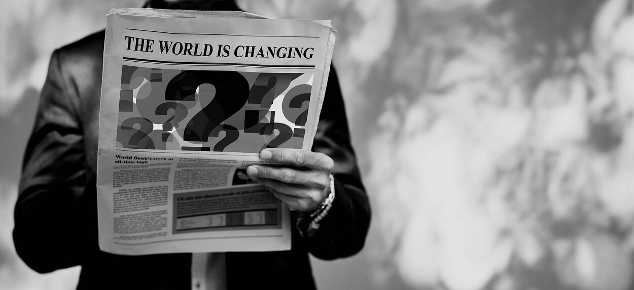 Image of a man holding a newspaper with the headline "the world is changing"