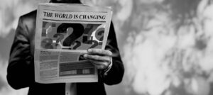 Image of a man holding a newspaper with the headline "the world is changing"